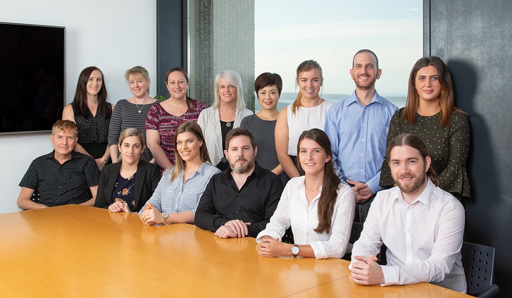 Professional staff team photograph at conference table in Sydney CBD highrise building