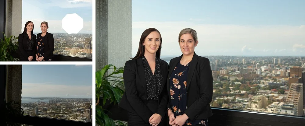 Professional team photograph against Sydney backdrop in CBD highrise building