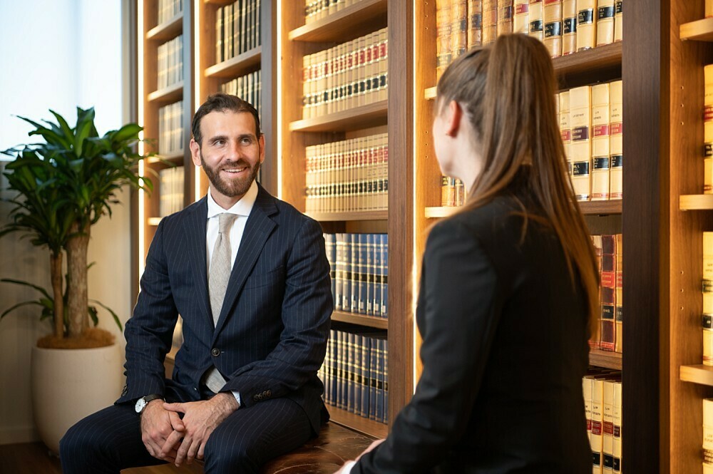 Lawyer in conversation in front of bookshelf